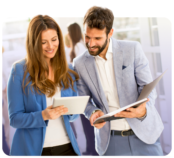 man and a woman looking down at a tablet and smiling