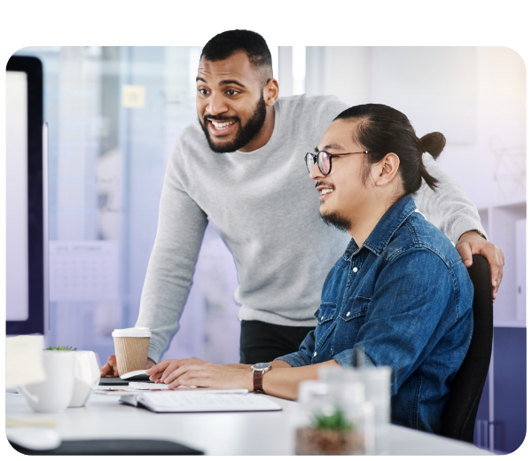 two men looking at a computer and smiling