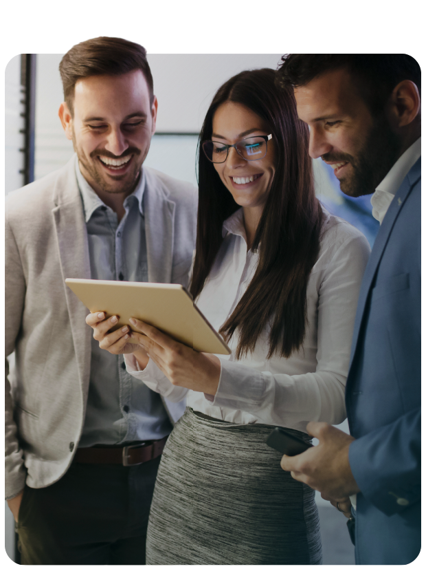 group of people looking down at a tablet and smiling