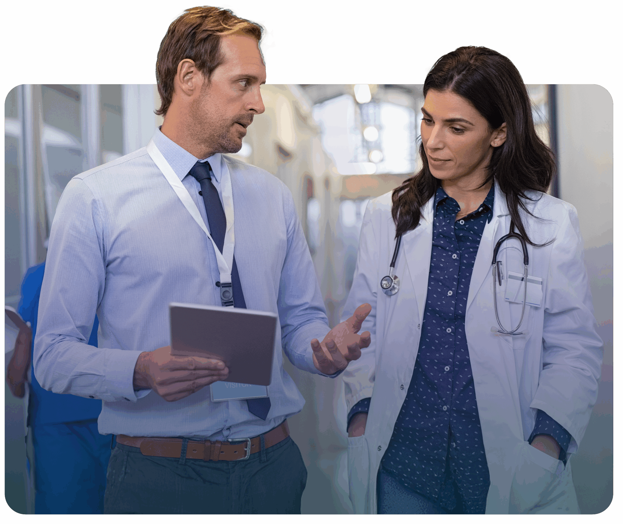man walking down a hall talking to a doctor 